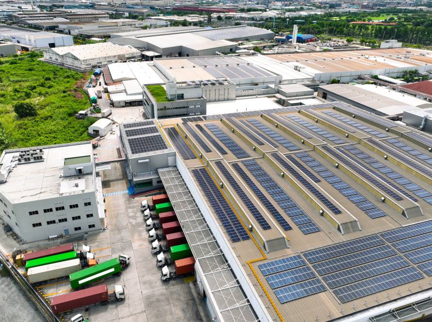 Solar-powered warehouse facility with freight trucks at loading docks. Eco-friendly logistics